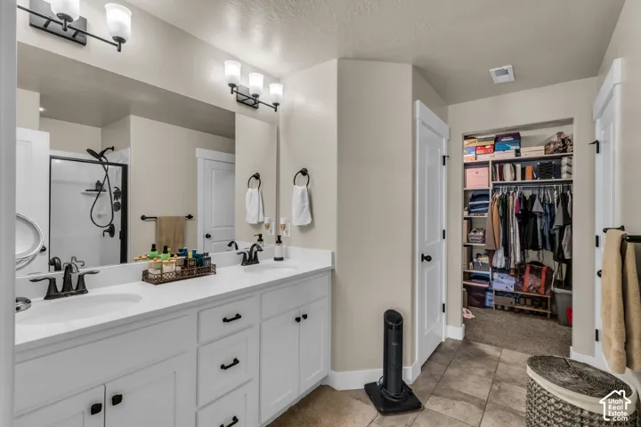 Dual vanity with white cabinetry, integrated sinks, and dark fixtures