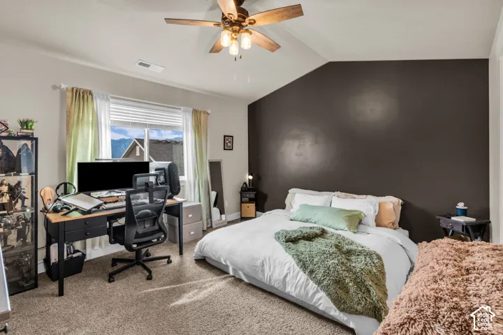Carpeted flooring, vaulted ceiling, ceiling fan with light fixture, and window with blinds