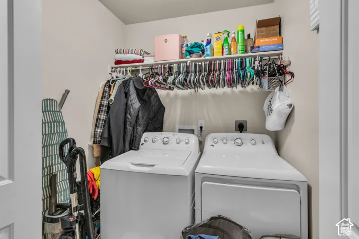Laundry area featuring a built-in shelf, clothes hanging rod, and light neutral wall paint