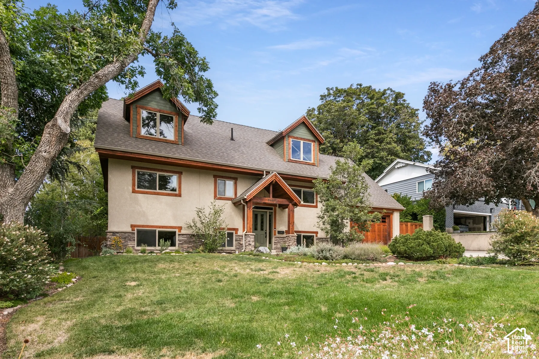 Contemporary stucco exterior with stone accents and a prominent front entry porch