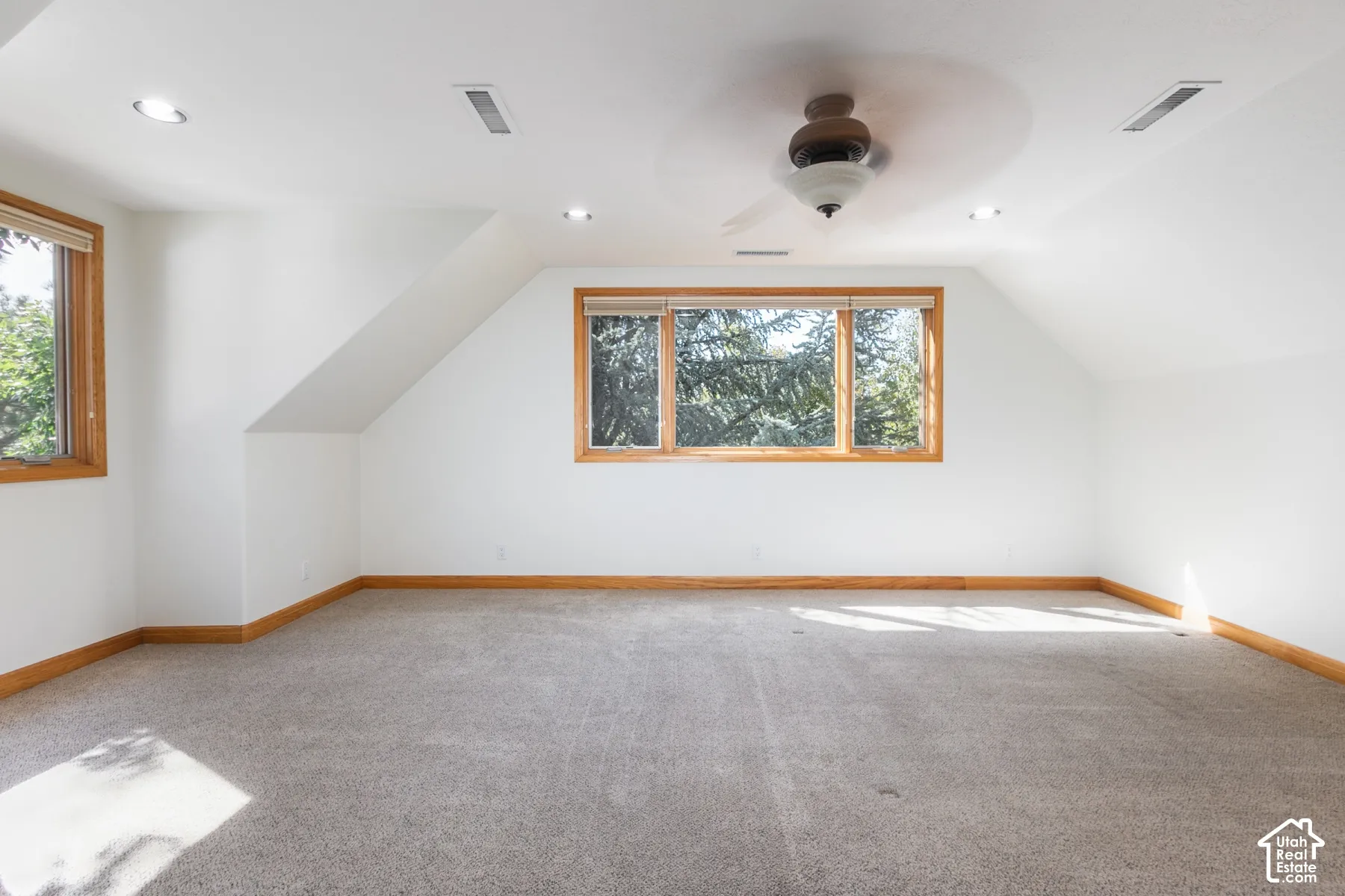 Carpeted room with wood-framed windows, a ceiling fan, and recessed lighting