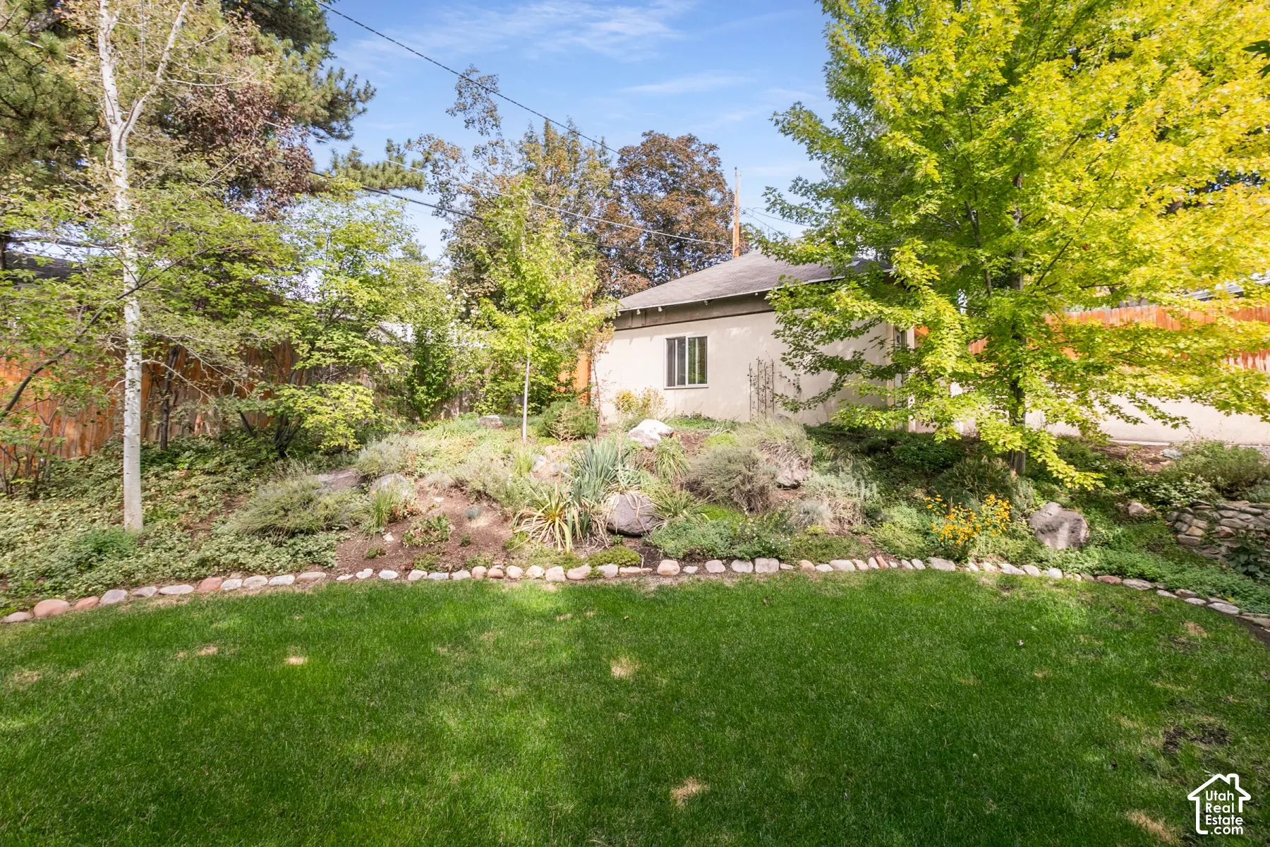 Lush lawn area bordered by a decorative stone edge and mature landscaping