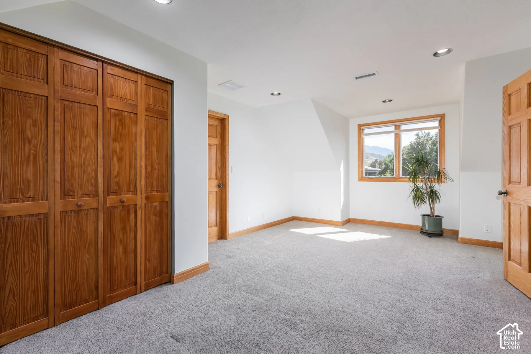 Plush gray carpeting, natural wood-finish trim, and recessed lighting