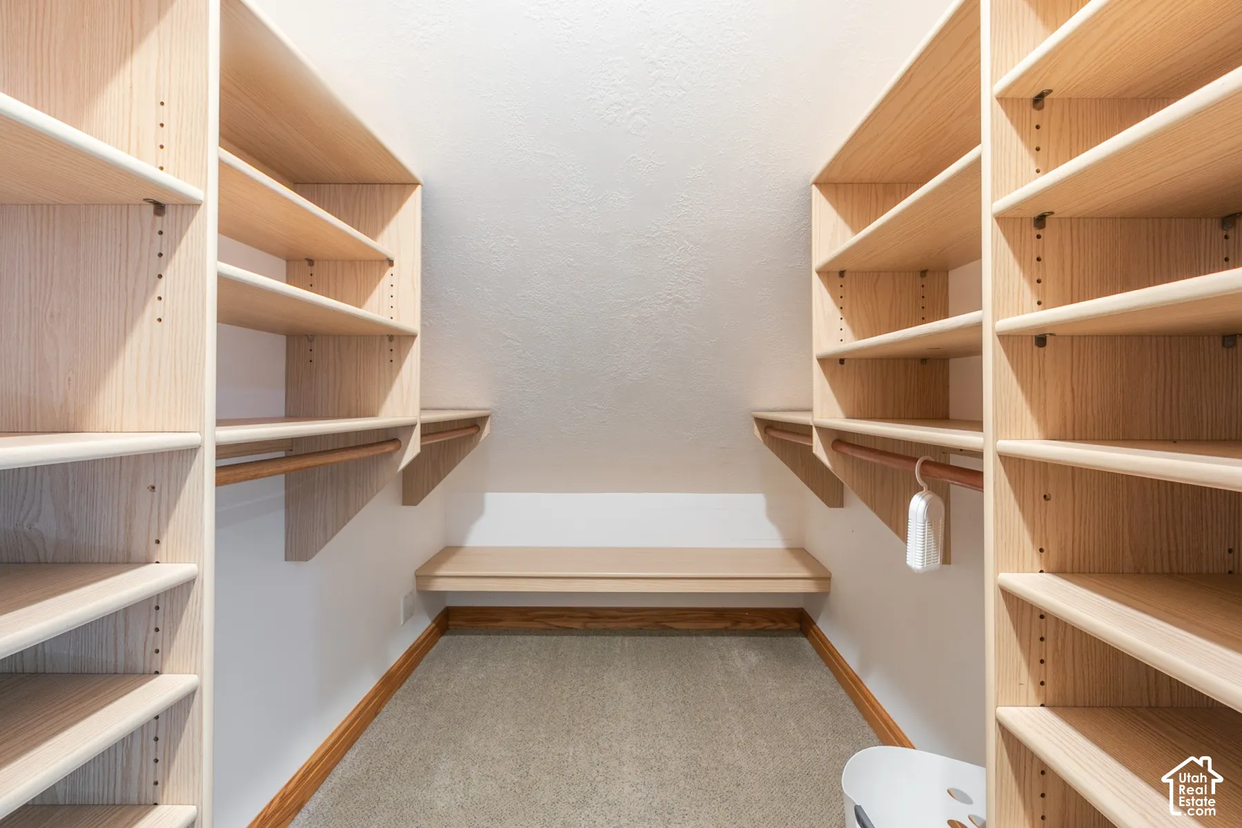 Built-in shelving units, adjustable shelves, built-in lower bench, clothes hanging rods, neutral carpet flooring