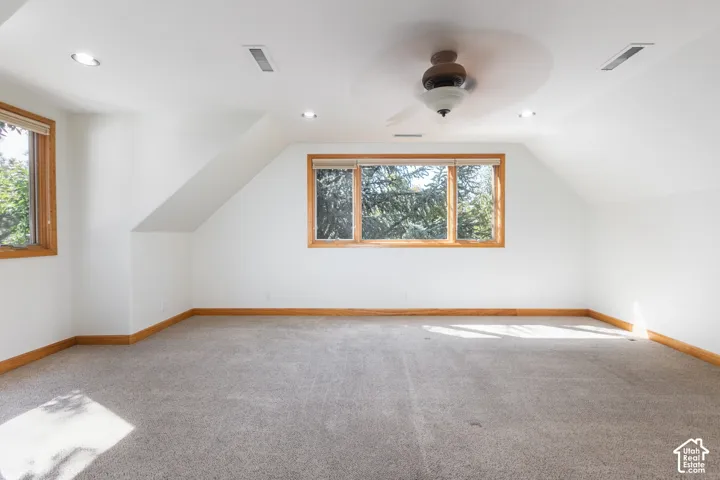 Carpeted room with wood-framed windows, a ceiling fan, and recessed lighting