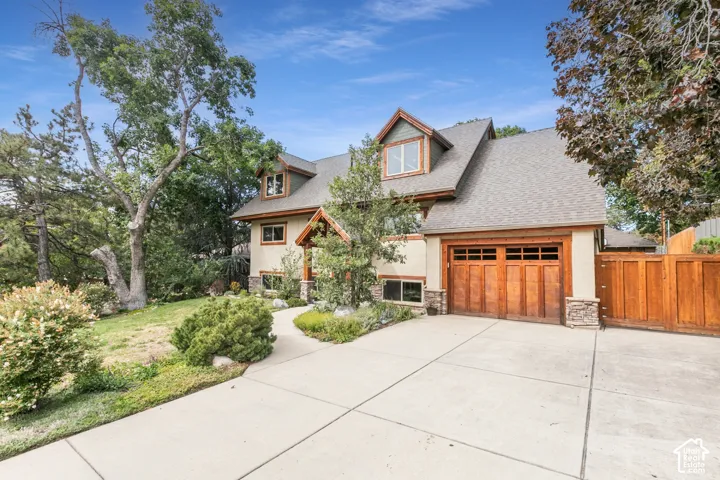 Craftsman-style exterior with wood garage door, stone accents, and dormer windows