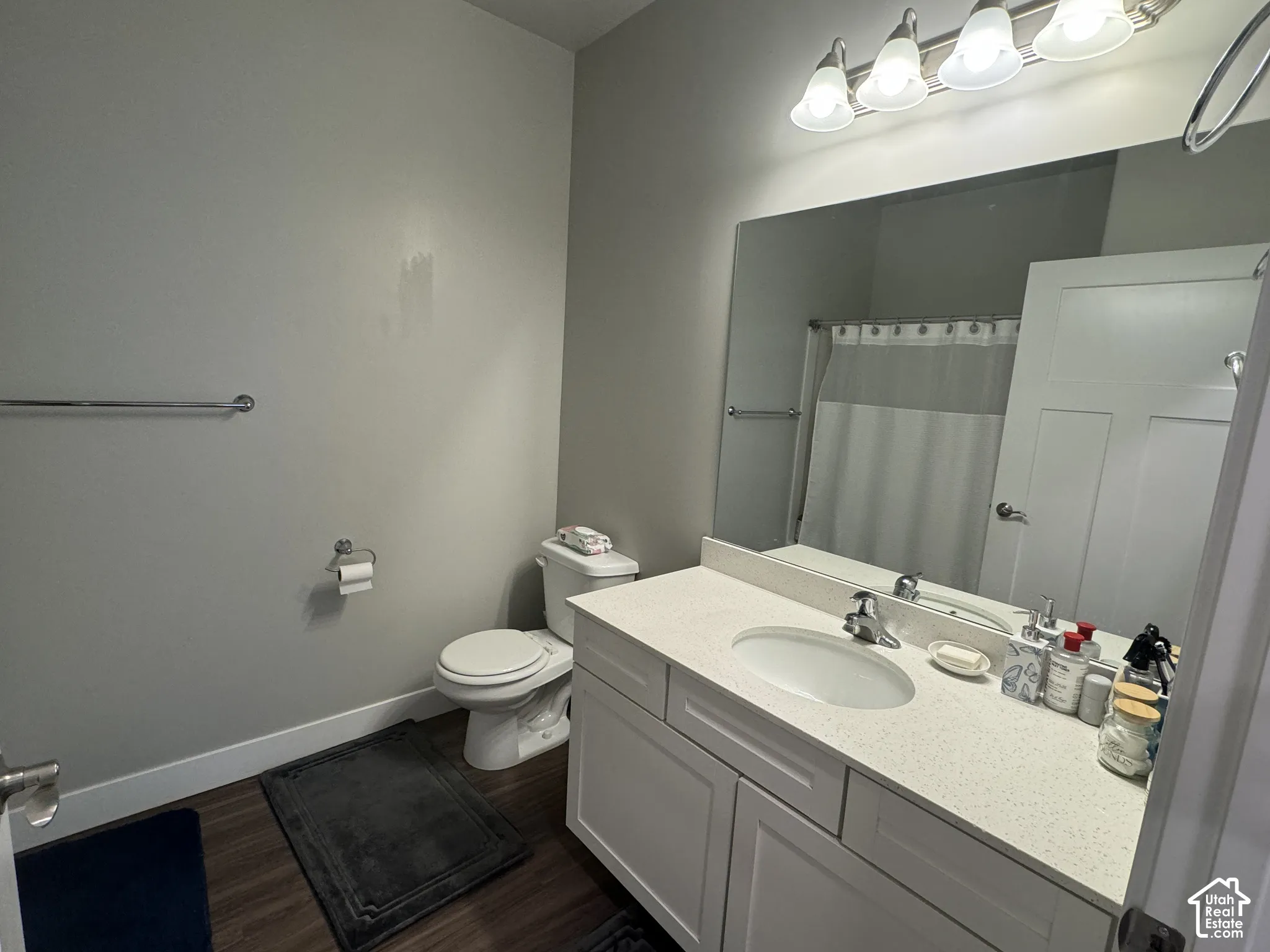 White vanity with a light-toned countertop, undermount sink, and chrome faucet
