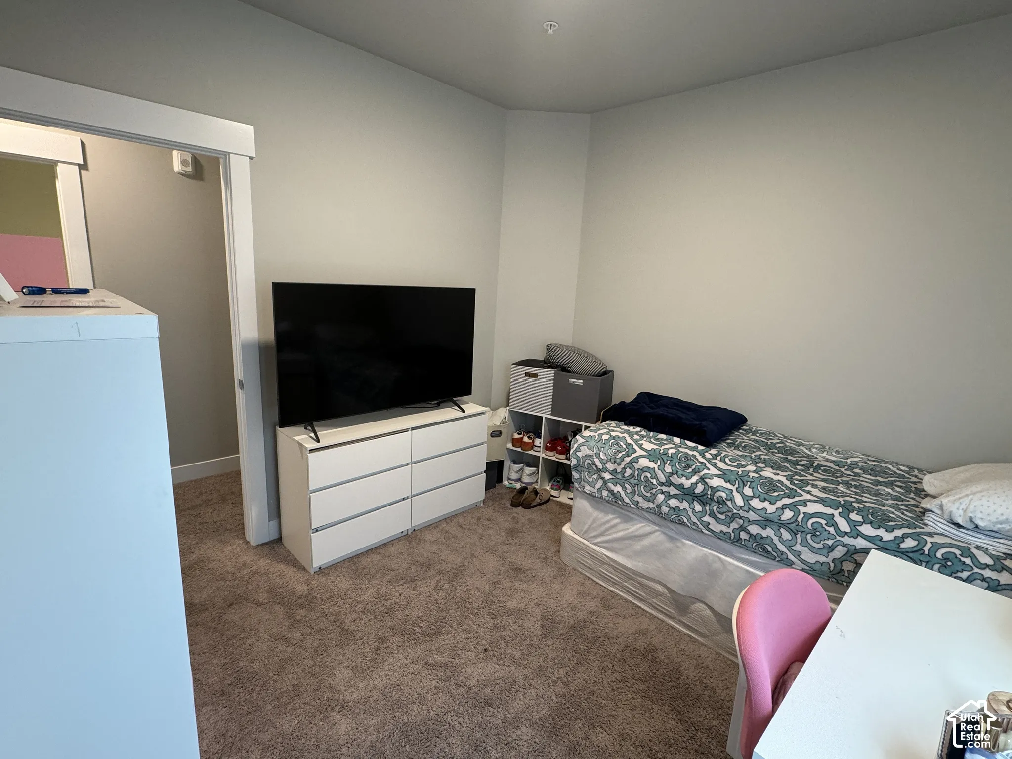 Neutral tone wall paint, neutral tone carpet, white trim, recessed lighting, and a doorway