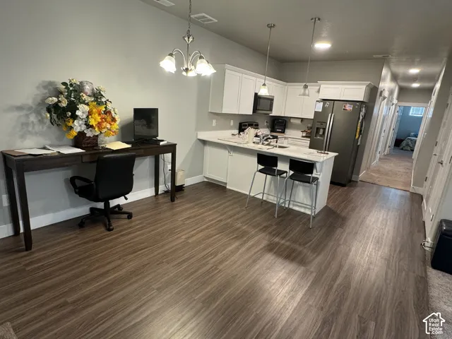 Kitchen with white shaker cabinetry, stainless steel appliances, and a peninsula with countertop seating