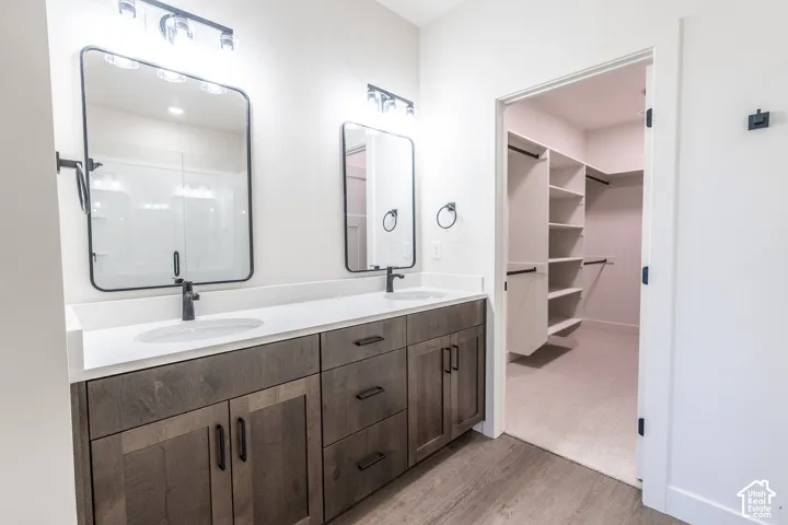 Double vanity with undermount sinks, wood-finish cabinetry, and matte black fixtures