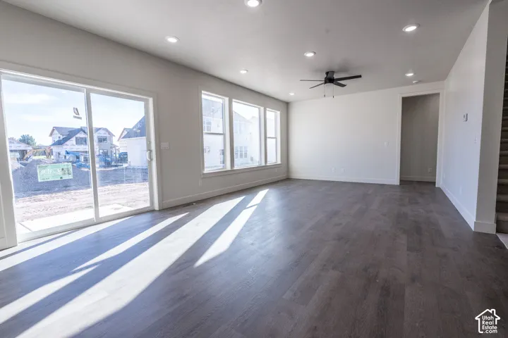 Spacious interior featuring wood-finish flooring, recessed lighting, a ceiling fan, and large windows with a sliding glass door