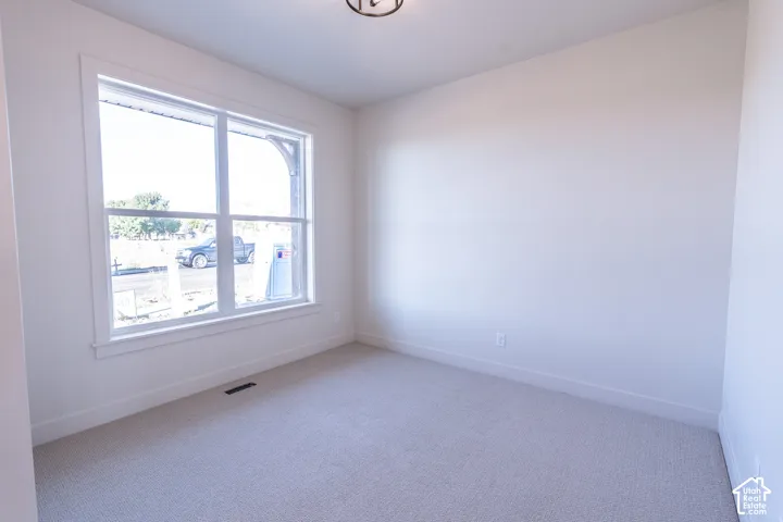 Recessed ceiling light fixture, white walls, white window trim, white baseboards, and light-colored carpet