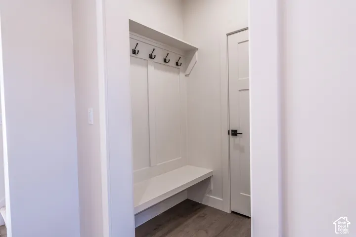 Built-in mudroom bench with paneled backing, integrated shelving, and black metal hooks