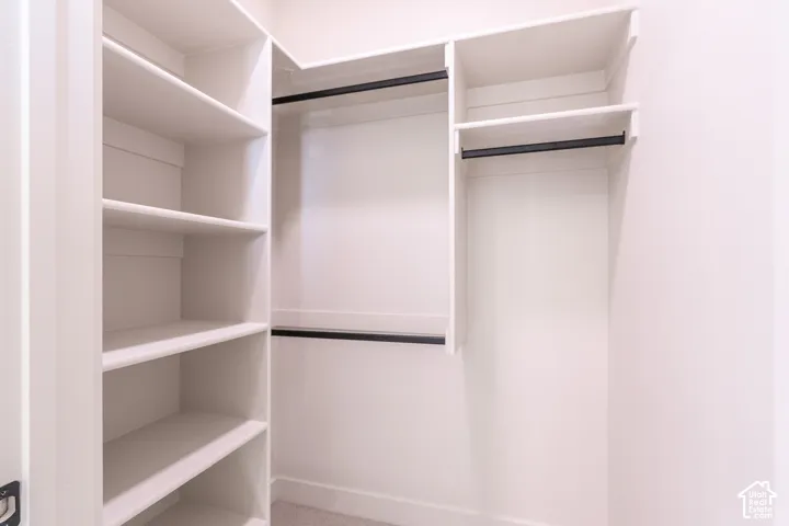 Built-in shelving, multiple hanging rods, and light-colored walls