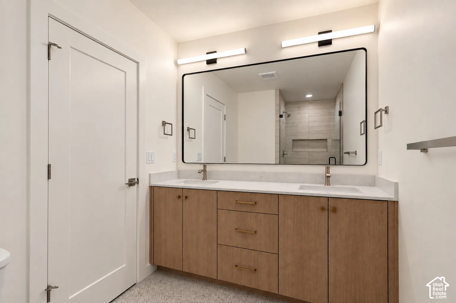 Floating wood-finish vanity with dual integrated sinks, quartz countertop, and brushed nickel fixtures