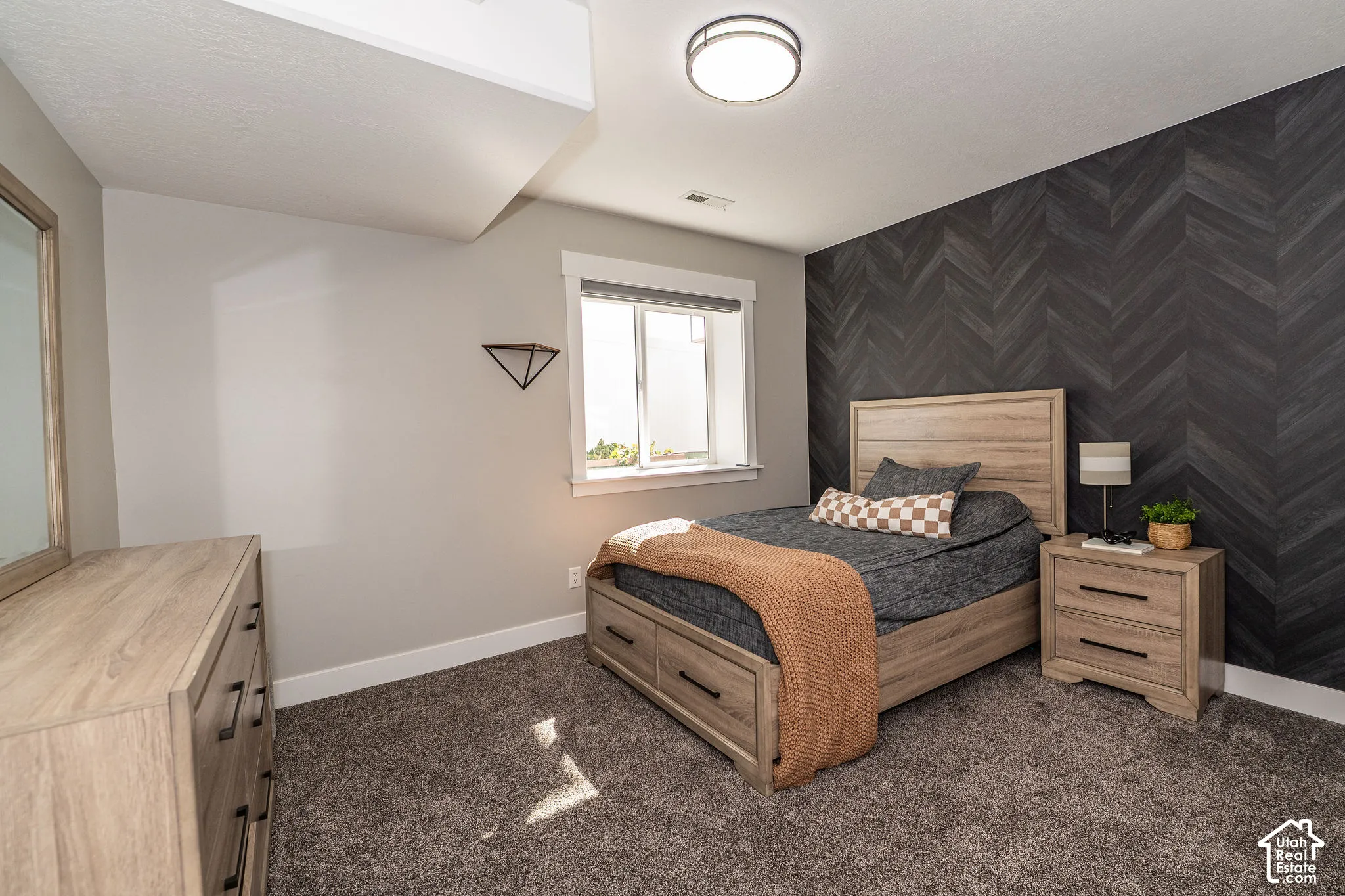 Herringbone accent wall, carpeted flooring, and a flush mount ceiling light