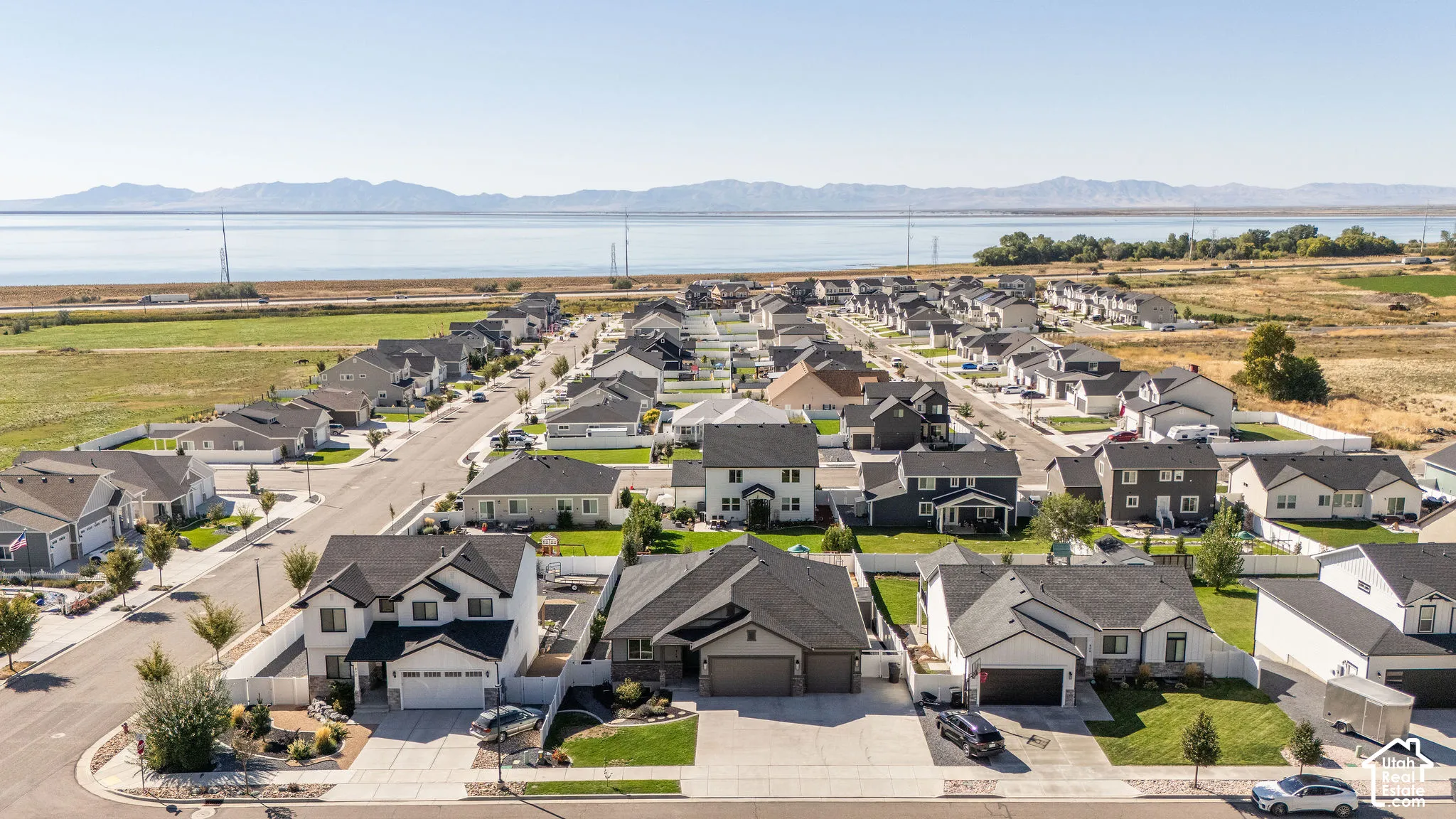 Aerial perspective showcasing a residential neighborhood with distant mountain and lake scenery