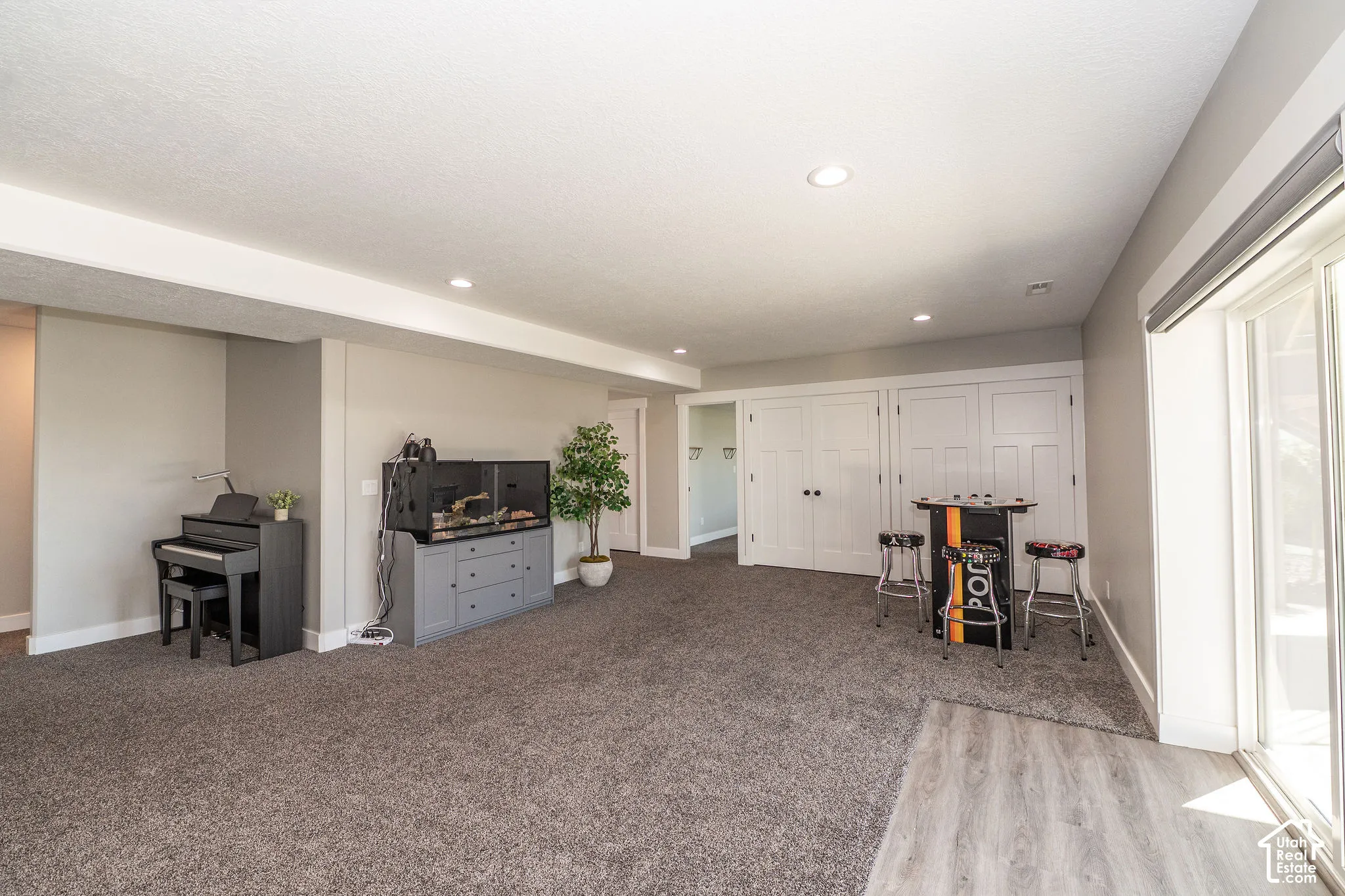 Recessed lighting, light gray wall paint, white trim, sliding glass door, and wood-finish flooring