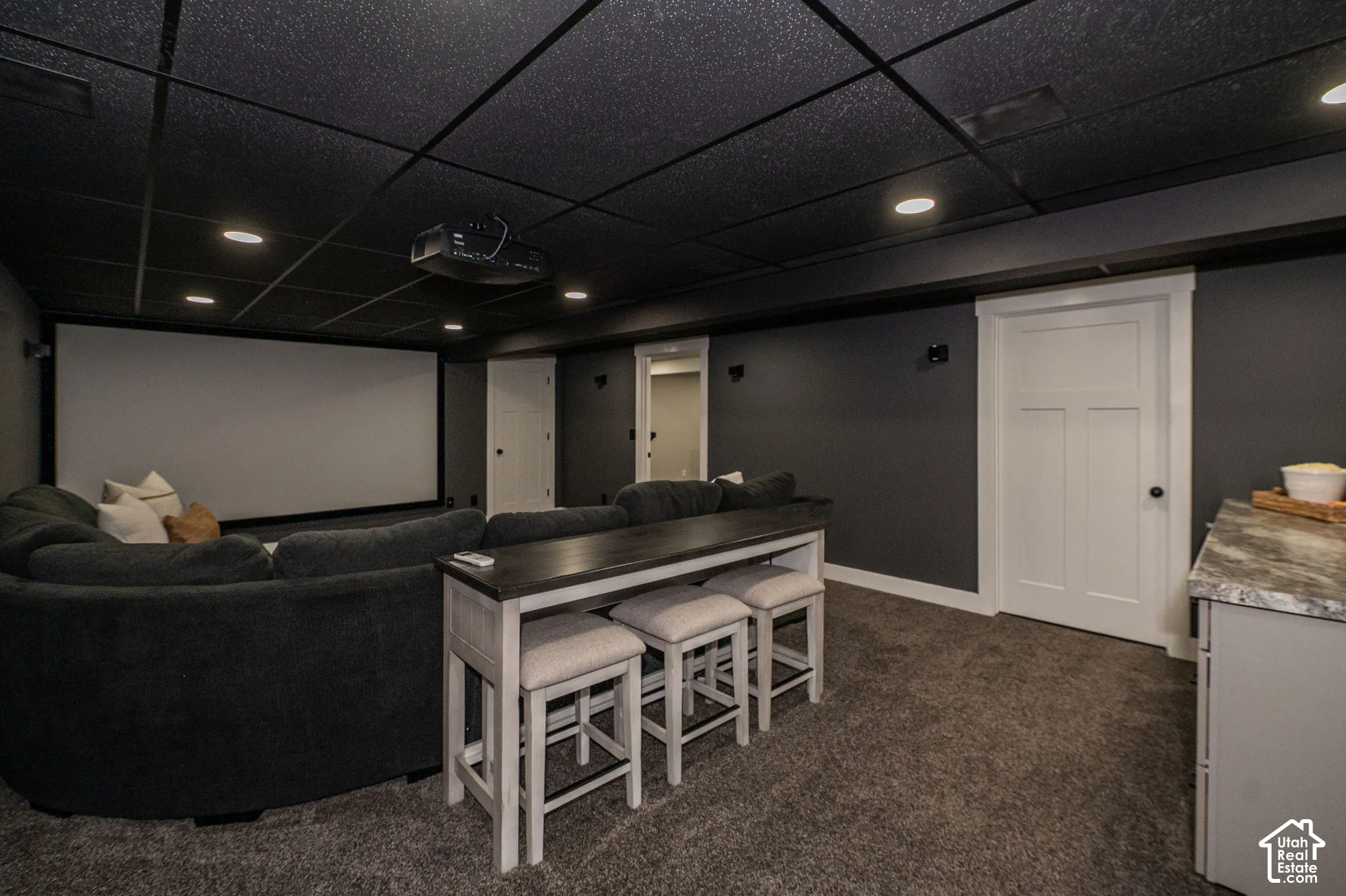 Recessed lighting, drop ceiling, wall-mounted projection screen, built-in cabinetry, and white paneled doors