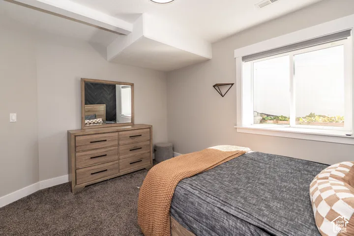 Carpeted room with a large egress window, light-colored walls, and white trim