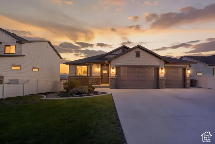 Contemporary-style home featuring stone and siding exterior, a two-car garage, and a concrete driveway