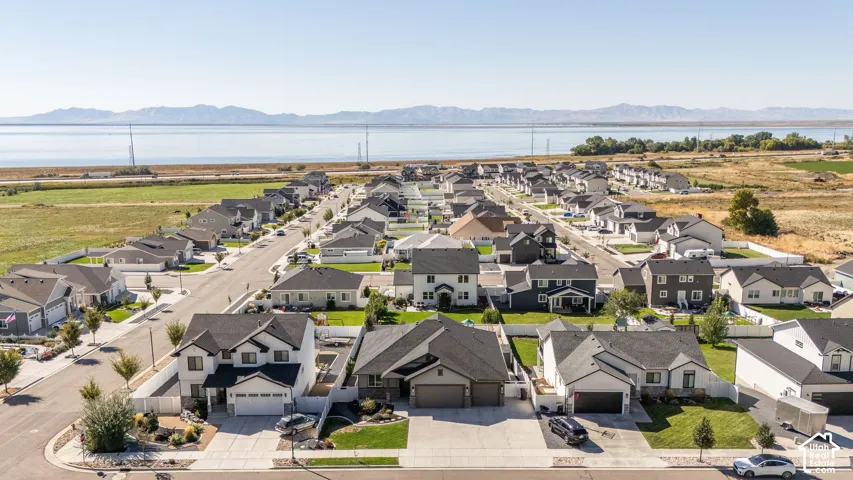 Aerial perspective showcasing a residential neighborhood with distant mountain and lake scenery