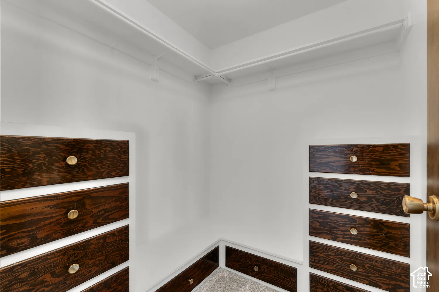 Walk-in closet with built-in dark wood-finish drawer units and integrated shelving