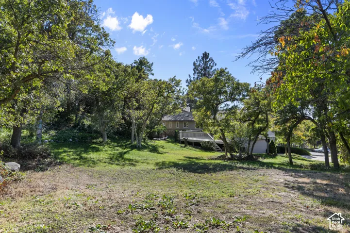Expansive property featuring mature trees and a multi-level deck