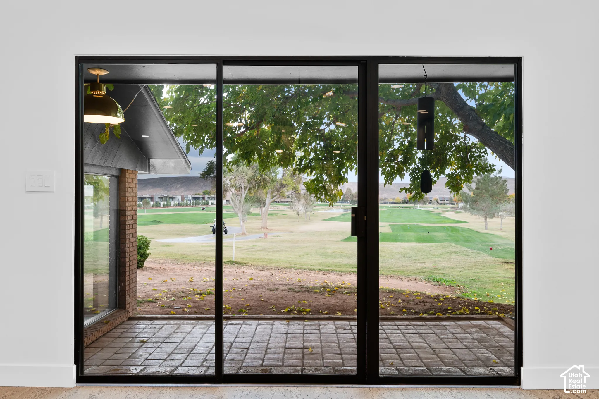 Expansive glass panel doors opening to a paved patio