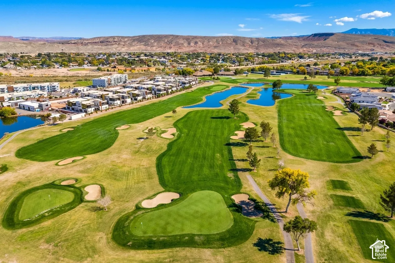 Expansive golf course setting featuring multiple greens, sand traps, and water features