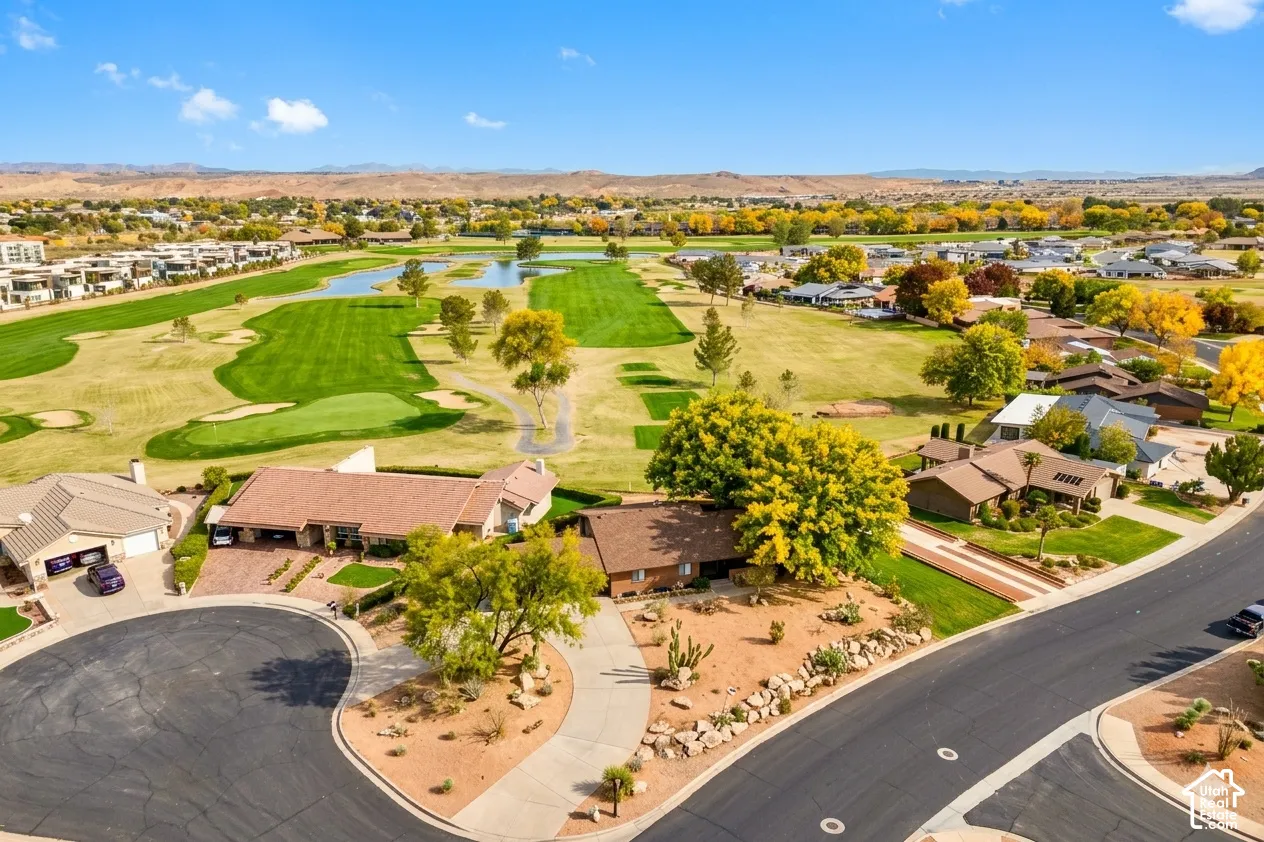 Golf course frontage with water features, mature landscaping, and mountain backdrop
