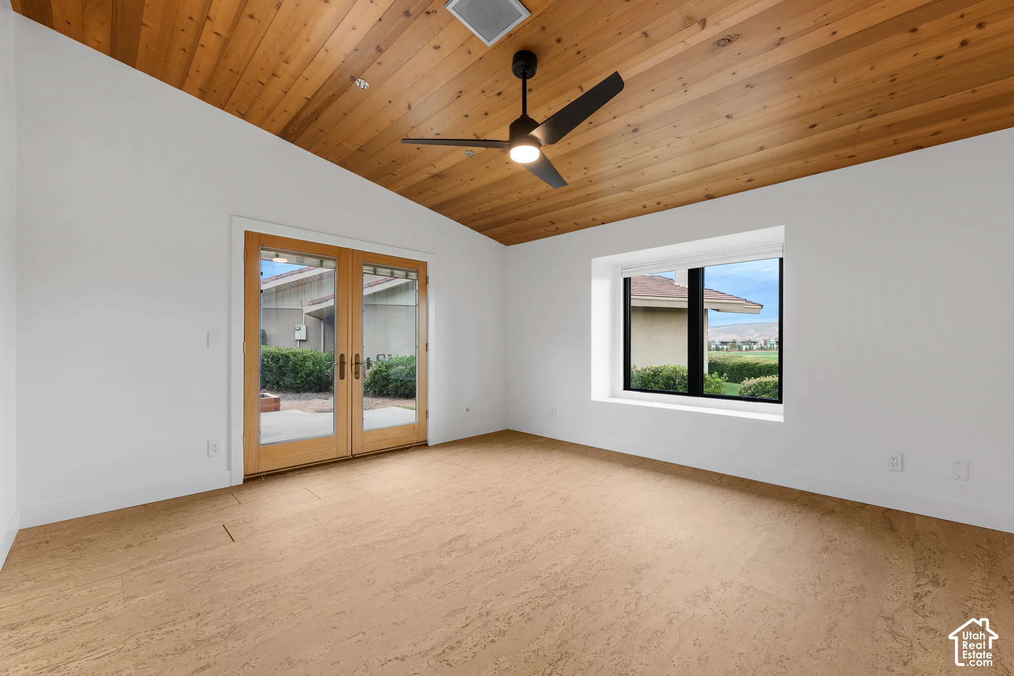 Vaulted wood-paneled ceiling with a ceiling fan