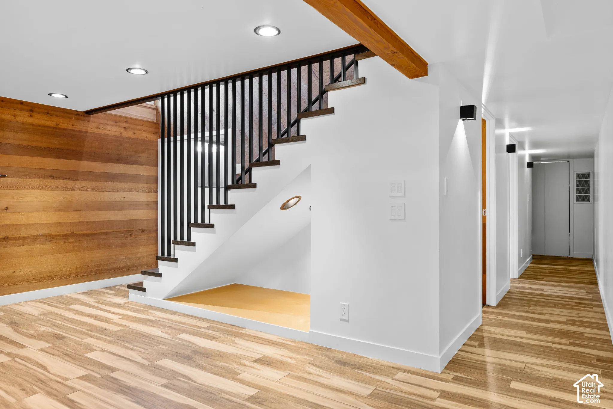 Wood-finish flooring throughout, complemented by a wood-paneled wall