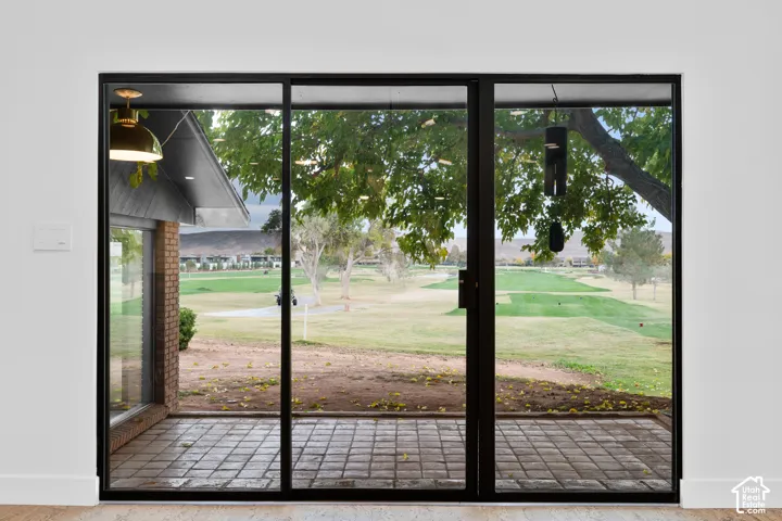 Expansive glass panel doors opening to a paved patio
