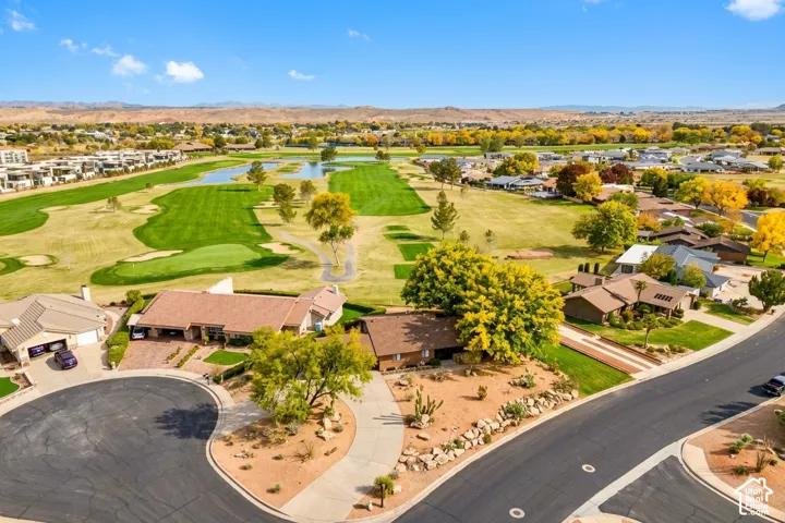 Golf course frontage with water features, mature landscaping, and mountain backdrop