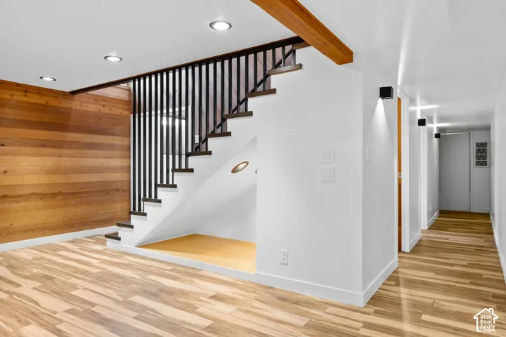 Wood-finish flooring throughout, complemented by a wood-paneled wall