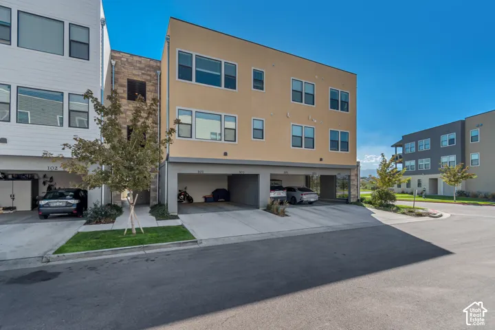 Multi-level exterior with a stucco facade and integrated covered parking bays