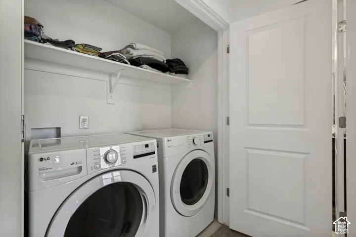 Integrated laundry space featuring a white built-in shelf and clean white walls