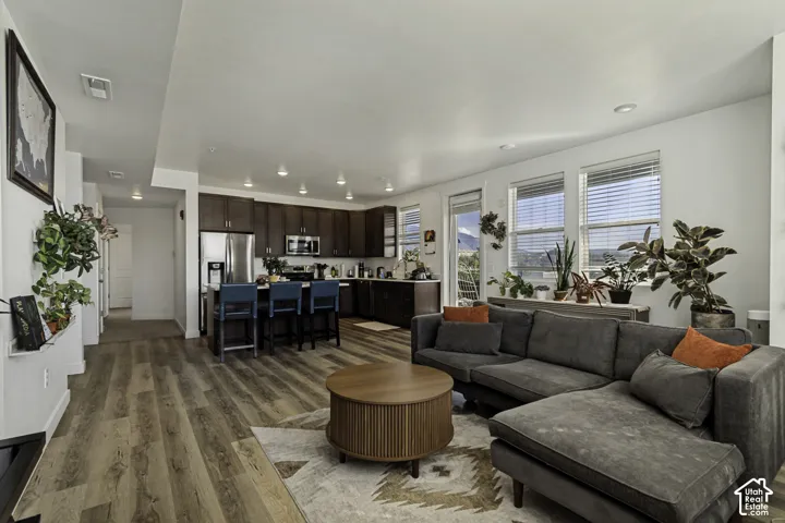 Open-concept living area featuring wood-finish flooring, recessed lighting, and large windows