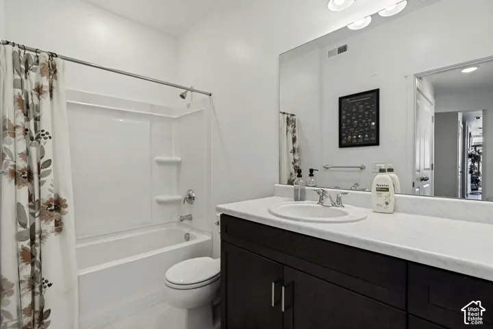 White single-piece bathtub and shower surround, dark wood-finish vanity with an integrated sink, polished chrome faucet, and a large wall-mounted mirror