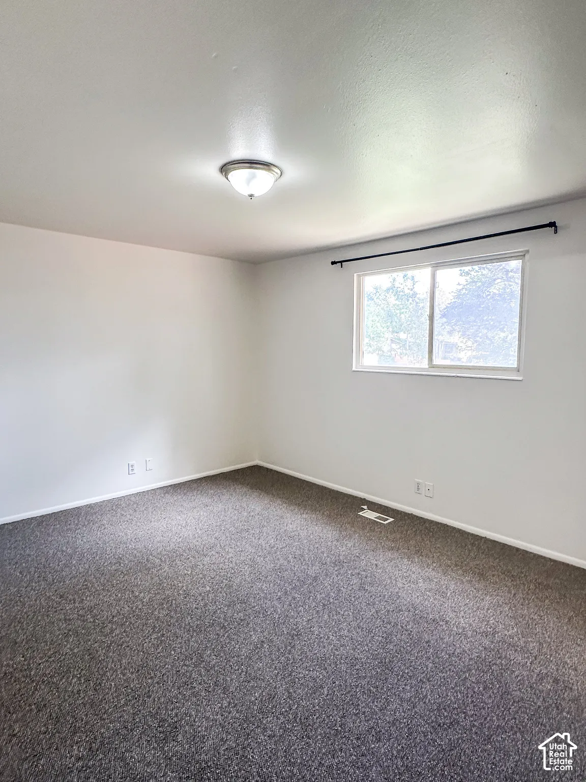Recessed lighting fixture, textured carpet flooring, and a large window