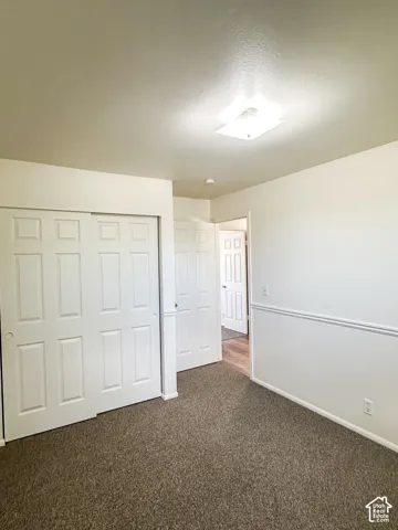Wall-to-wall carpeting with light-toned walls, featuring a chair rail molding