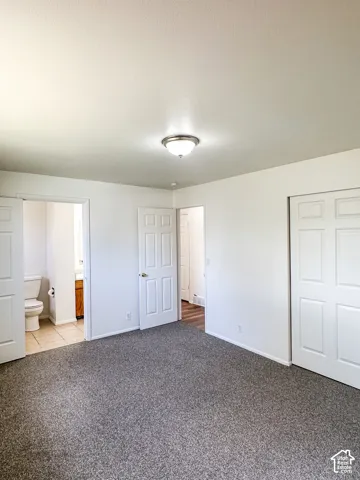 Neutral-toned wall-to-wall carpeting, white walls, and a semi-flush mount ceiling light fixture