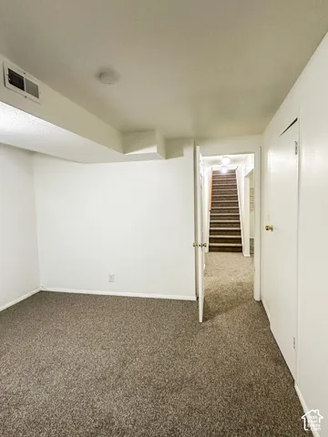 Wall-to-wall carpeting throughout, clean white walls, and a recessed ceiling light