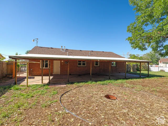 Red brick exterior with a rear covered patio and exposed wood beams