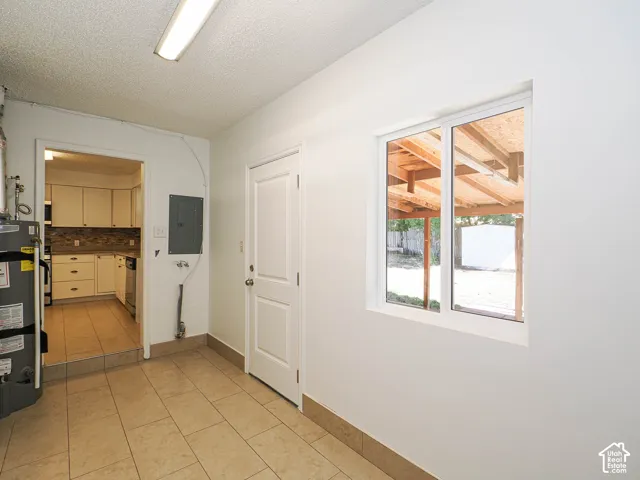 Tile flooring, white painted walls, white door, and a white-framed window