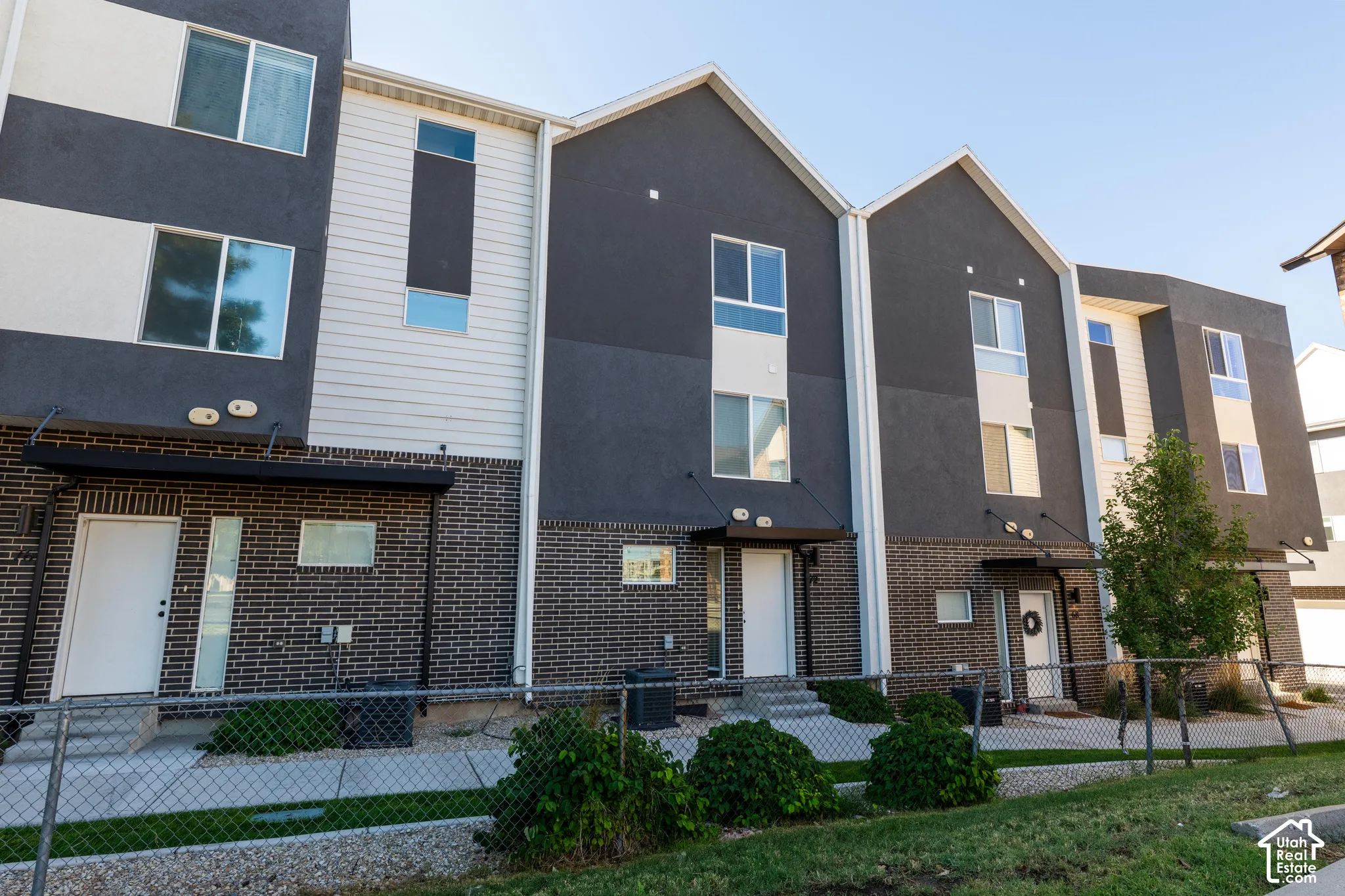 Modern townhome exterior featuring an ash brick facade and a multi-textured finish