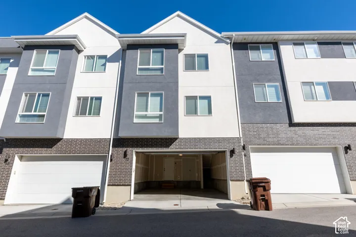 Contemporary exterior featuring a multi-tone facade, integrated garage parking, and multiple large windows