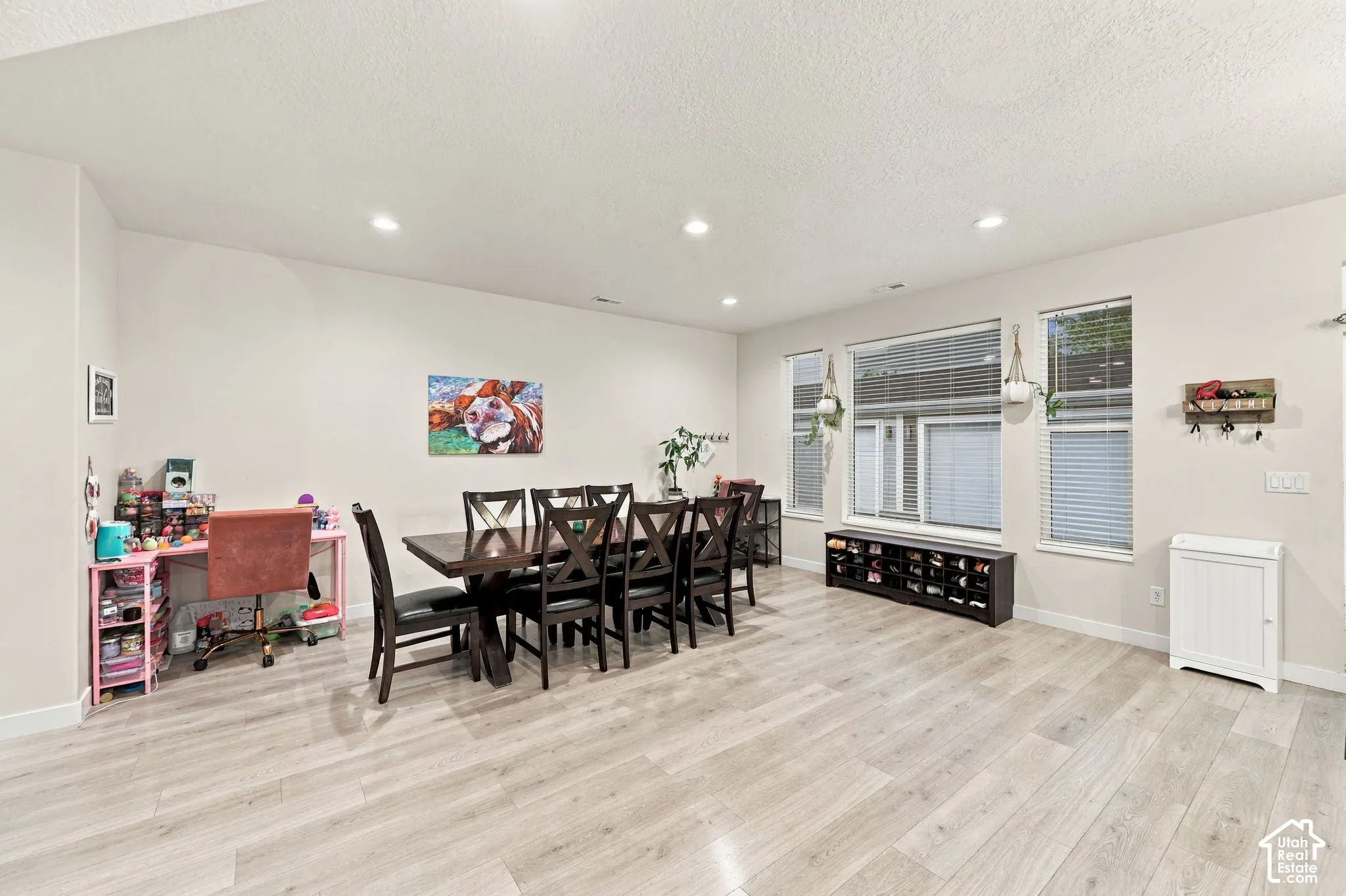 Recessed lighting, wood-finish flooring, and multiple windows with blinds