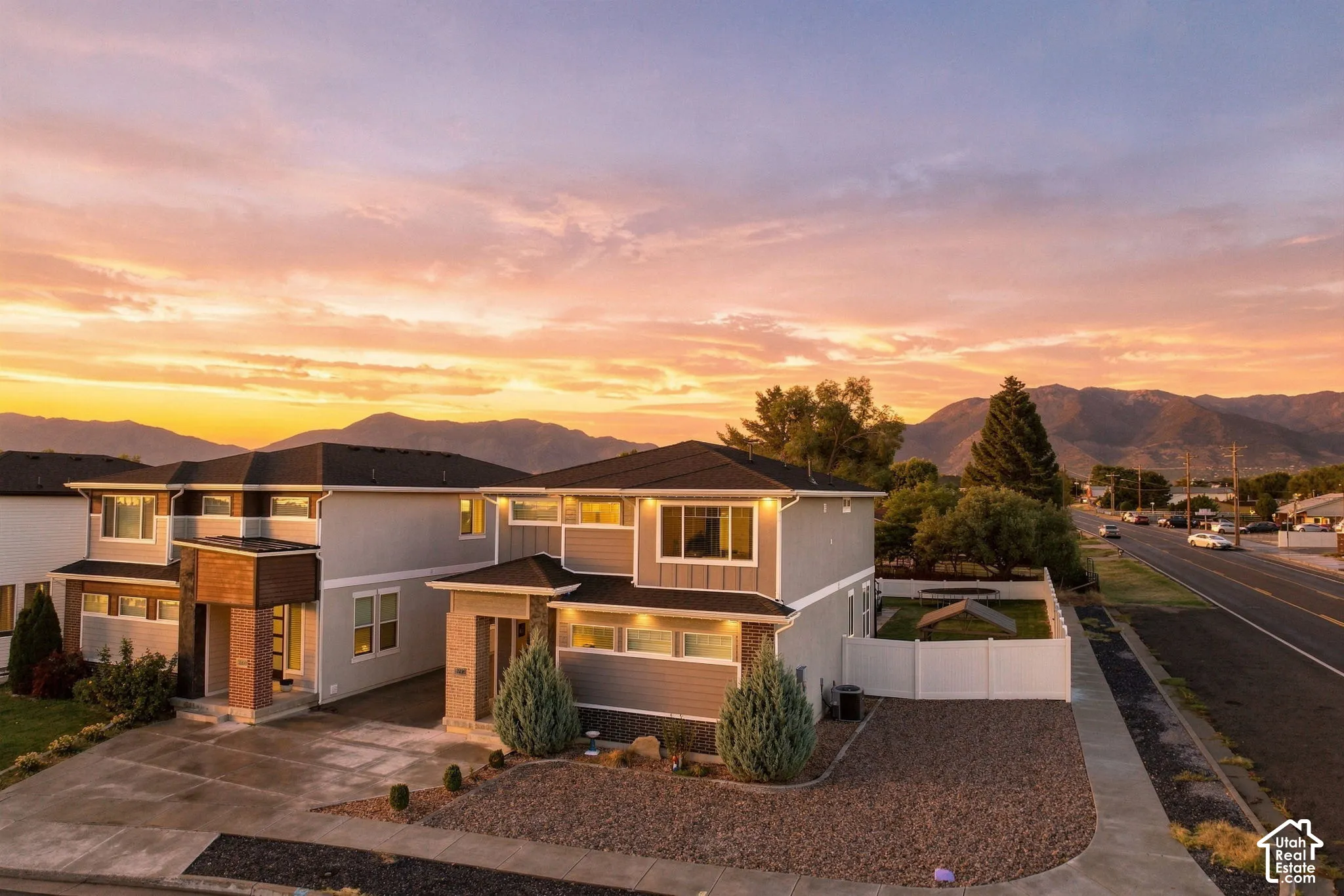 Contemporary exterior with varied siding, an attached garage, and a gravel driveway